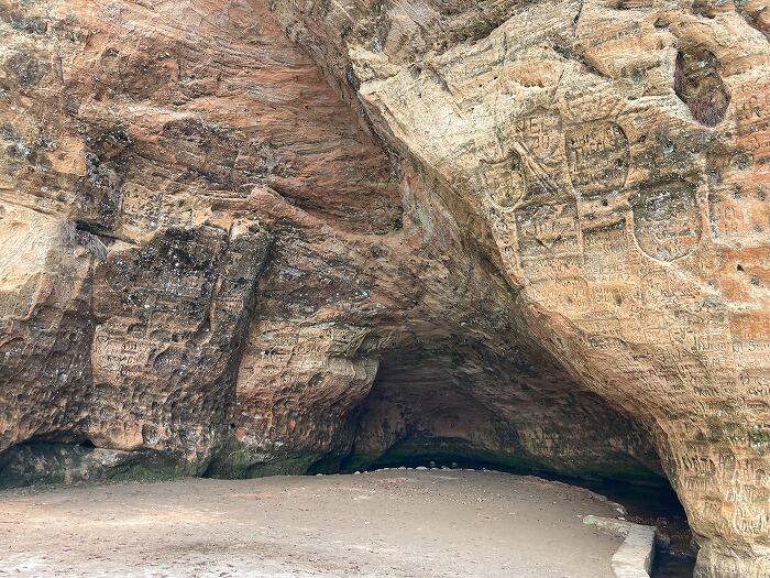 洞穴をよく見ると壁面にびっしりとはんこを押したような落書き?の跡がある。私が見つけた古いものだと1822年!