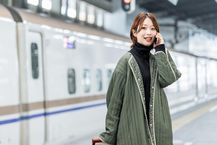 新幹線に乗って旅行に出かける女性
