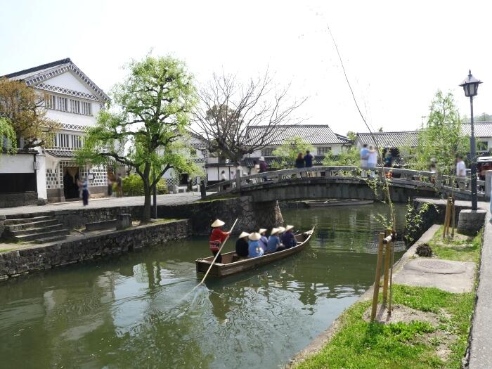 ＜「中橋」へ進む木船。左岸のなまこ壁が美しい蔵は「倉敷考古館」＞