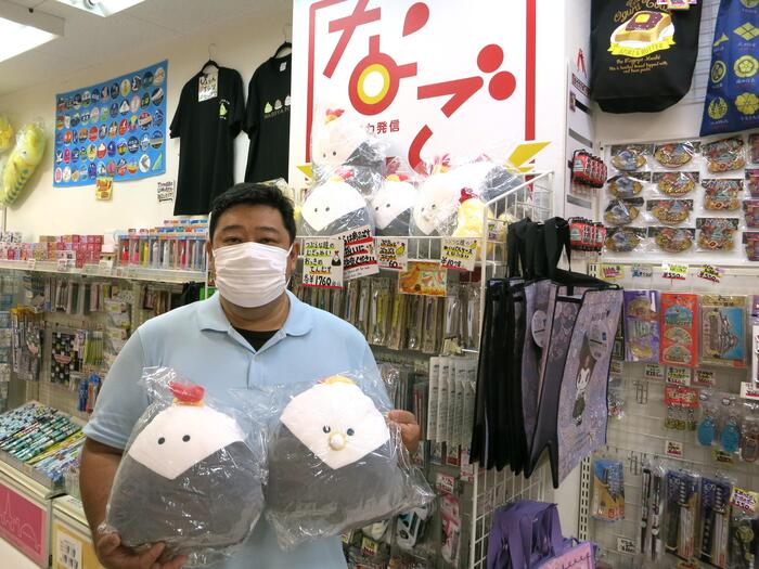 つぶらな瞳のむぎゅぬいおっきめ　てんむすのぬいぐるみを持つ店長