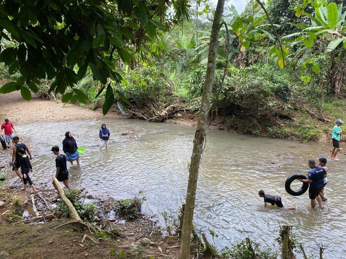 川があって子どもや家族が川遊びしている