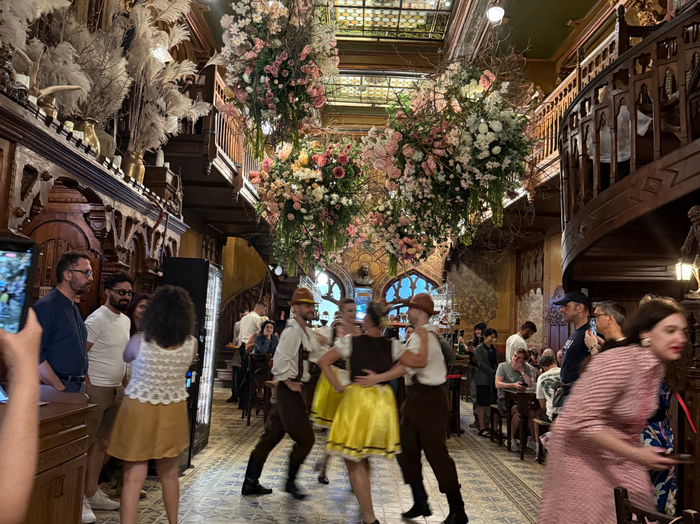 店内で民族ダンスが披露され、伝統衣装に身を包んだダンサーたちがステップを踏む様子