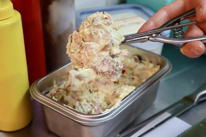 容器からサラダをすくうところ