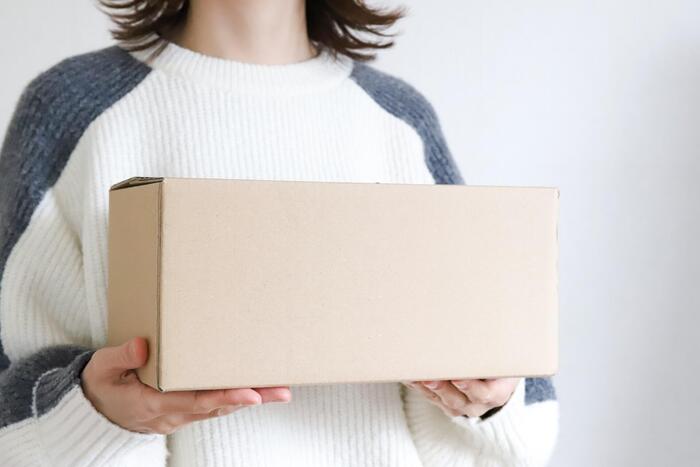 段ボール箱を持つ女性
