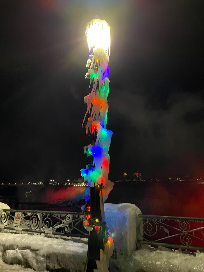 クリスマスライトの上に氷柱をまとった街灯