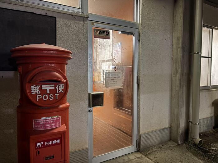 共同浴場の入口に立つレトロな赤ポスト