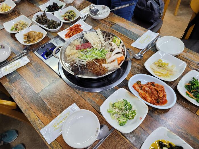 ーブルにずらりと並ぶおかずは、山菜のナムルや新鮮な野菜