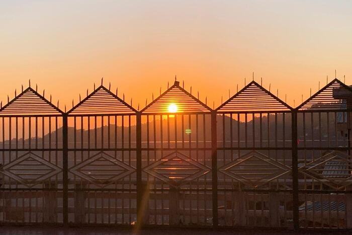 柵のある建物に沈むインドの夕焼け