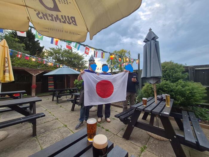 サッカーワールドカップのイギリスのパブのテーブル、日本の旗を掲げる筆者