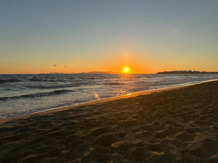 ティノス島のビーチに美しい夕日が沈む