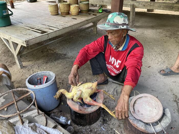 タイの暮らし、丸ごと鳥の焼いている男性