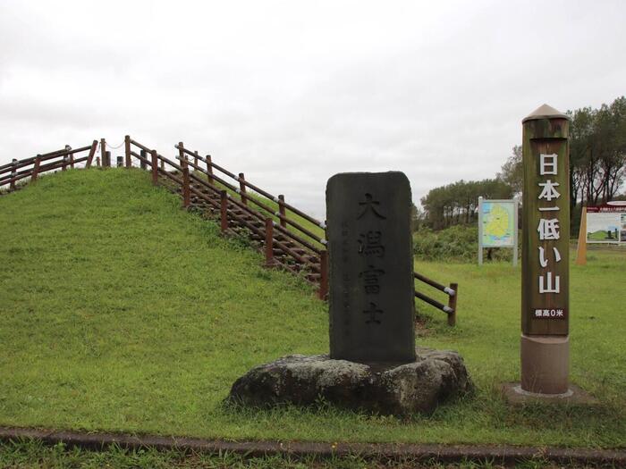 日本一低い山と書かれた看板と山の頂上