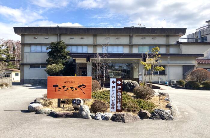 上杉謙信ゆかりの宿「生地温泉たなかや」の外観と歴史ある温泉旅館の看板