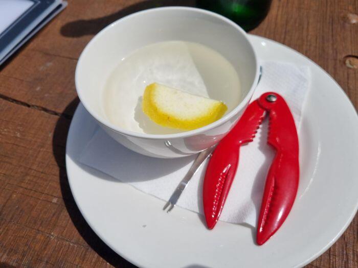 カニを食べる専用のカニのカタチをしたハサミとレモンと水の入った器