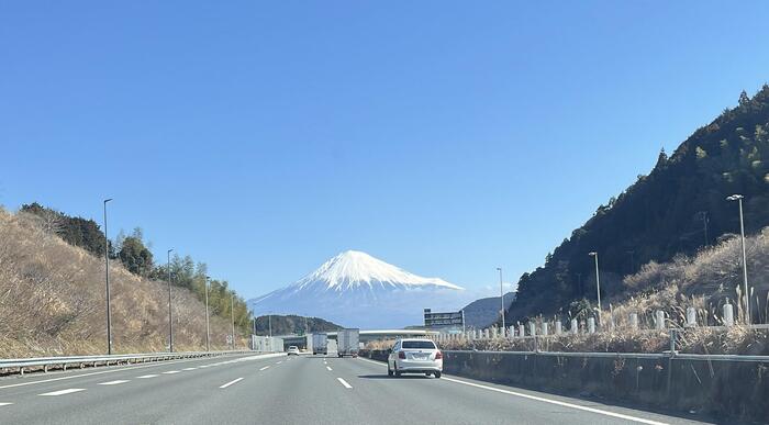 道路から青空の前方に富士山が見える