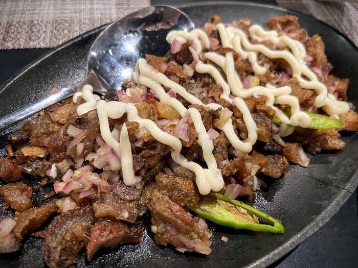 フィリピングルメ　ポーク・シシグ、豚肉焼いたものにマヨネーズソースがかかった料理