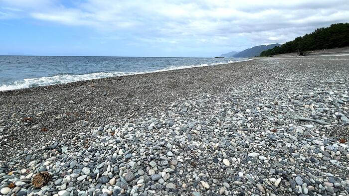 朝日町ヒスイ海岸の波打ち際に広がる丸い小石とヒスイ探しを楽しめる浜辺の風景