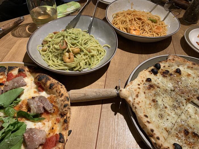 スパゲッティ、ピザなどボリュームのある料理が並ぶ食卓