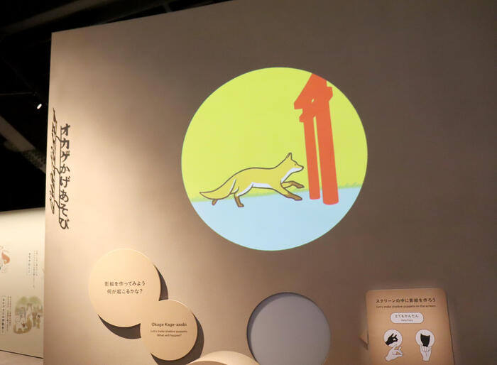 オカゲ屋敷で手影絵をスクリーンにかざして遊ぶ体験の様子