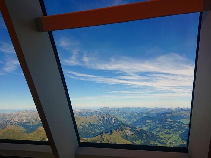 レストランLe 3の大きな窓から見えるアルプスの山々と青空