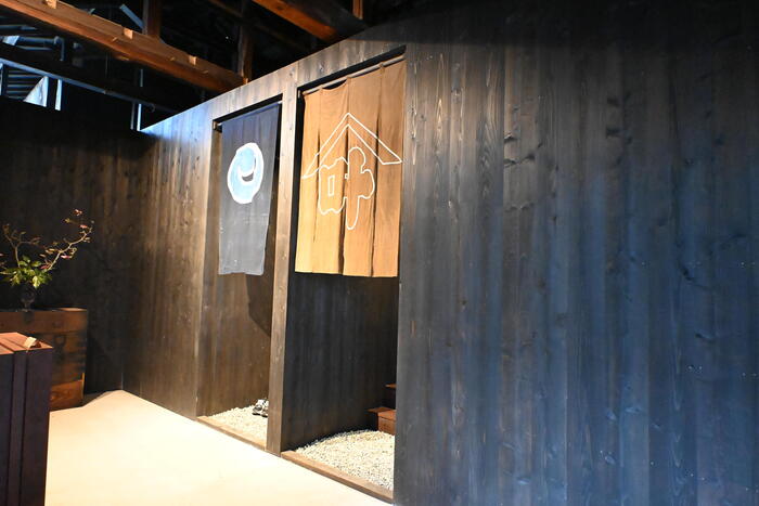蔵を活用したbon-sauna Uの入口にかかる屋号入りの藍染めのれん