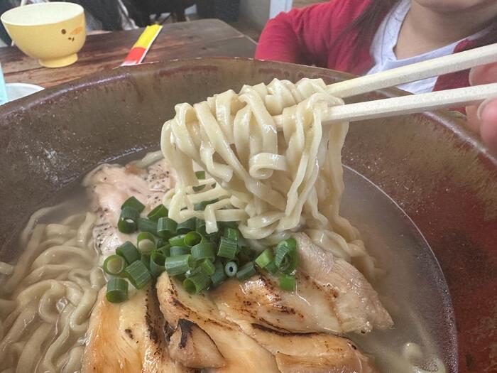 あっさりとしながらコクがあるスープと麺を箸であげる様子