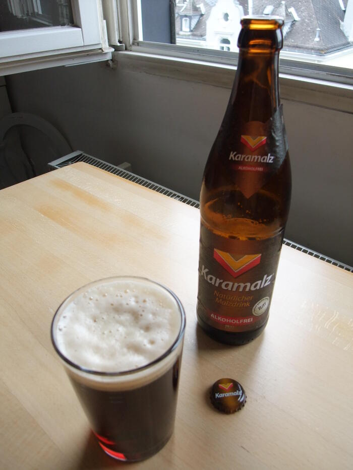 瓶に入った大麦を使ったノンアルコール飲料がカップに注がれている