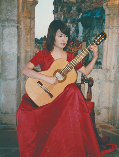 赤いドレスでギターを演奏する村治佳織さん