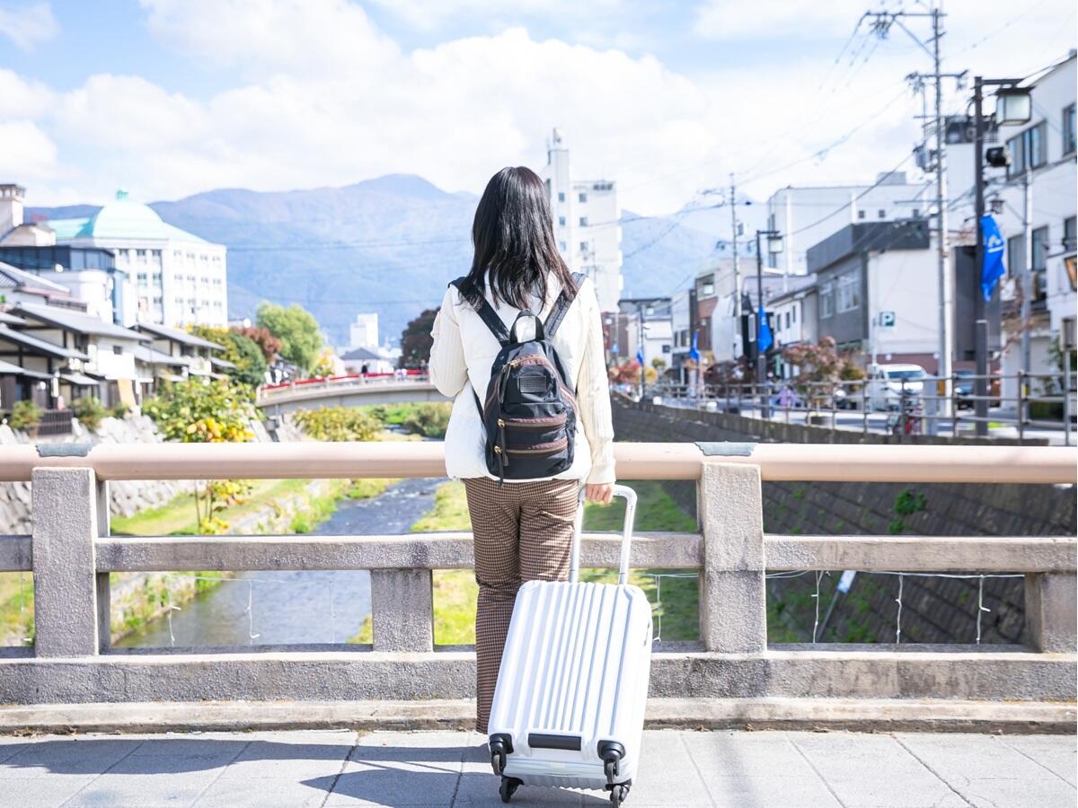 キャリーケースを持つ一人旅の女性